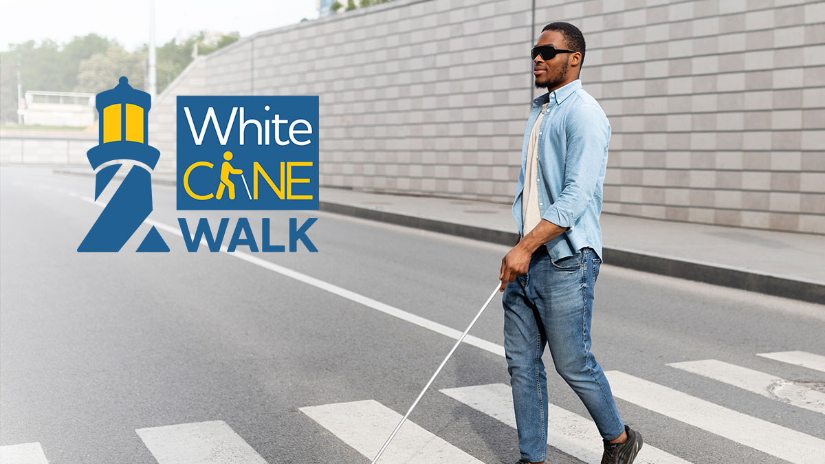 Blind man crosses the street using his cane for the First Annual White Cane Walk of Lighthouse of the Blind and Low Vision in Tampa, Florida.